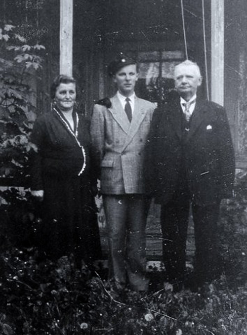 Hans Jenssen i midten, sammen med sine foreldre Ingeborg og Henrik Jenssen. Henrik Jenssen var handelsmann i Sk�lv�r fra 1911 til 1959, s�nnen Hans fra 1959 til 1962. Bildet er tatt utenfor lysthuset i hagen.