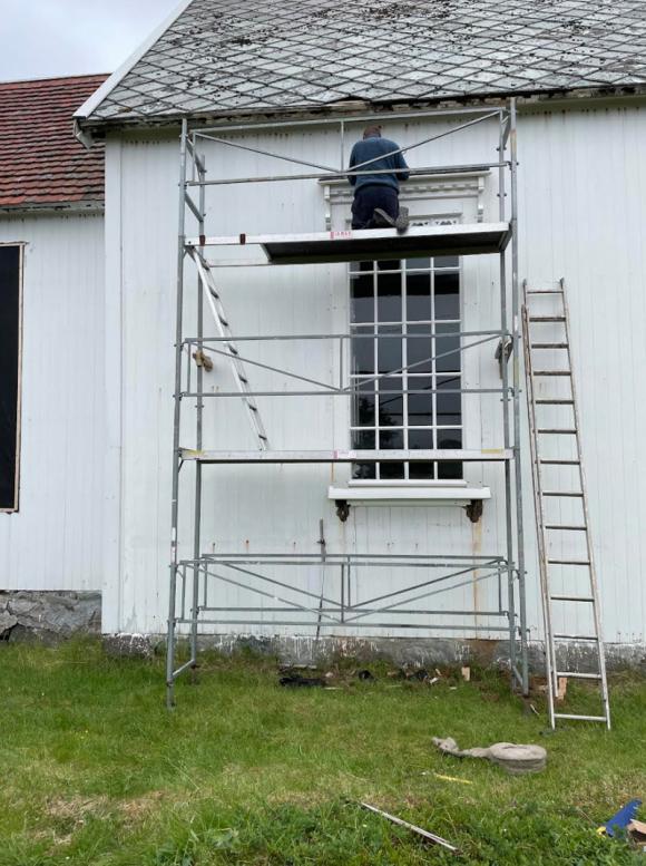 Kirkevindu settes inn etter reparasjon.