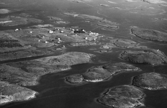 Skålvær sett fra sørvest på slutten av 1960-tallet. Vi ser at en del av bygningene i det gamle gårdstunet ennå står.