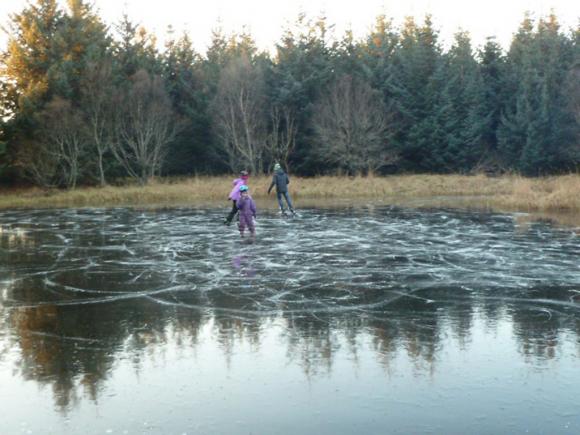 Langvarig frost og klarv�r har gitt knallhard blankis p� Dammen i januar 2014. I bakgrunnen Kristoffer, Maren og Sara.