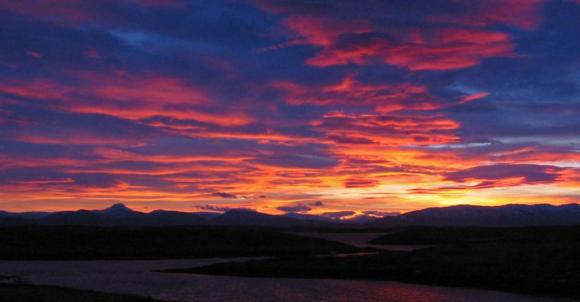 Sol bak fjellene i �st.
